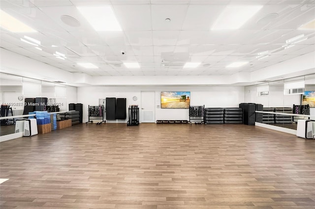 interior space featuring a paneled ceiling and hardwood / wood-style floors