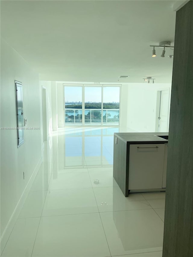 hallway with rail lighting and light tile patterned flooring