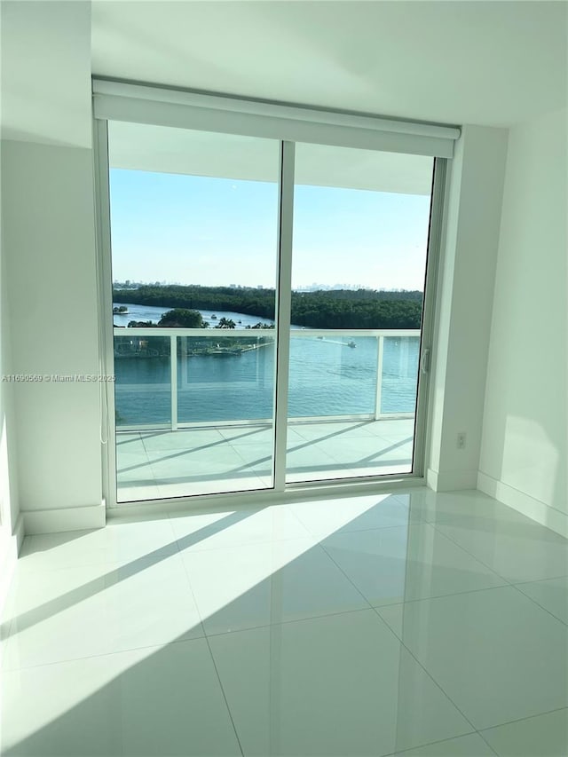 tiled empty room featuring a water view