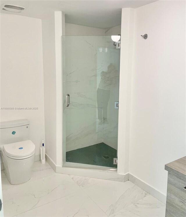 bathroom featuring an enclosed shower and toilet