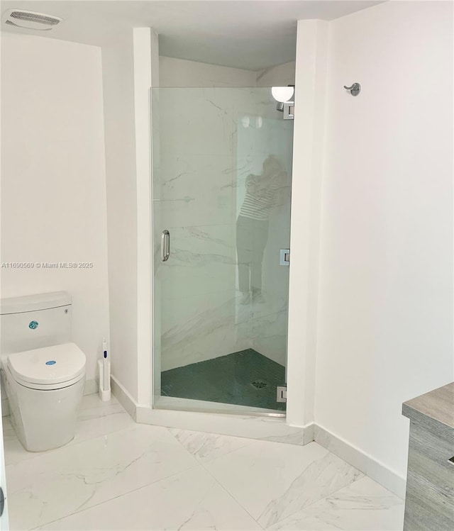 bathroom featuring walk in shower and toilet