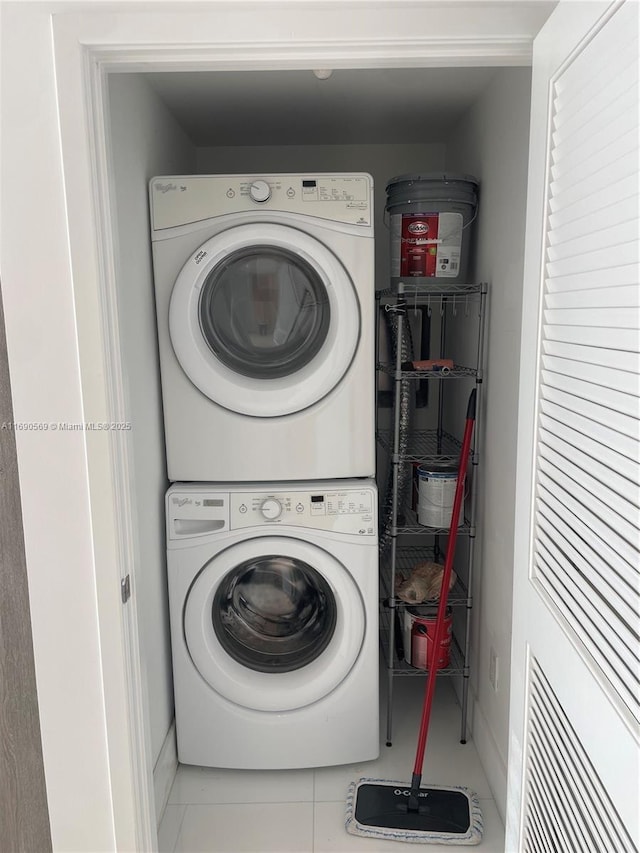 laundry area featuring tile patterned flooring and stacked washer / dryer