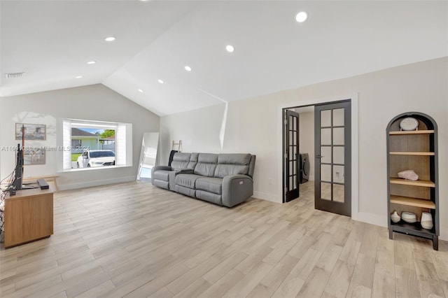 living room featuring light hardwood / wood-style floors, vaulted ceiling, and french doors