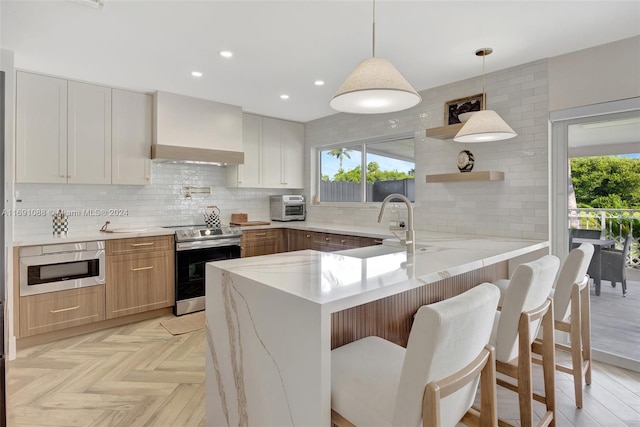 kitchen featuring stainless steel appliances, kitchen peninsula, custom range hood, pendant lighting, and decorative backsplash