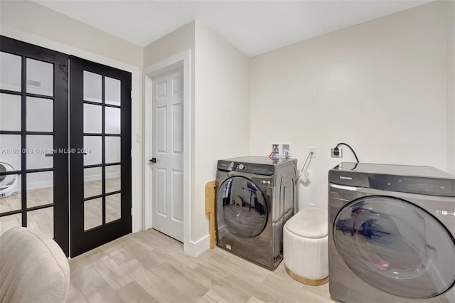 laundry area with french doors, light hardwood / wood-style flooring, and washing machine and dryer