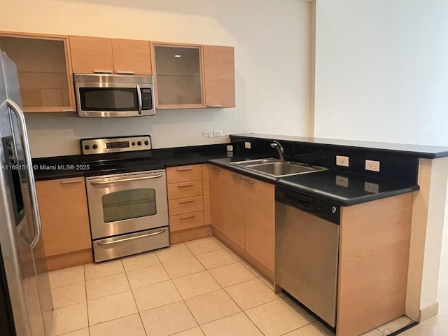 kitchen with sink, stainless steel appliances, light tile patterned flooring, kitchen peninsula, and light brown cabinets