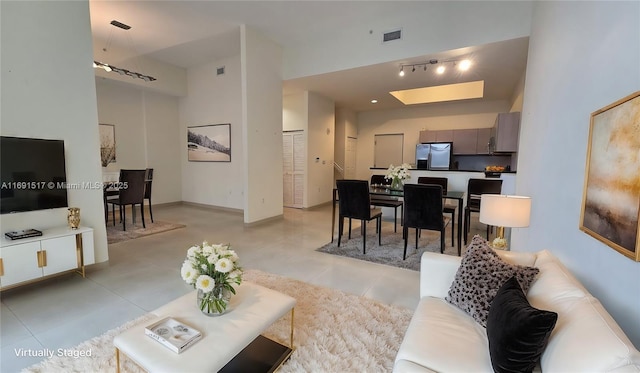 living room with light tile patterned flooring and a towering ceiling