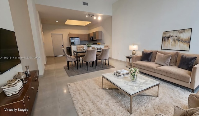 tiled living room featuring a skylight