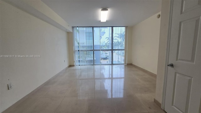 unfurnished room featuring floor to ceiling windows and light tile patterned floors