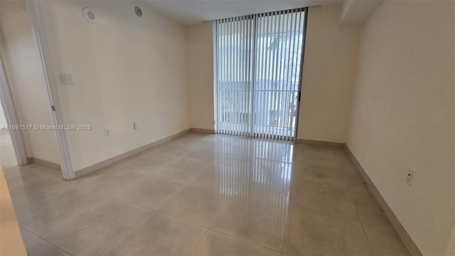 unfurnished room with expansive windows and light tile patterned floors