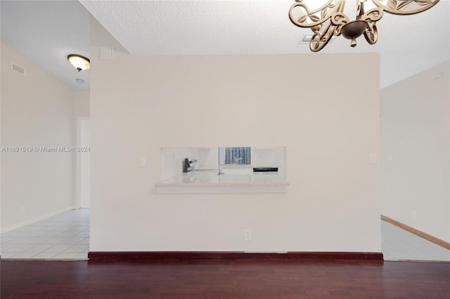 interior space featuring a chandelier, a textured ceiling, and hardwood / wood-style flooring