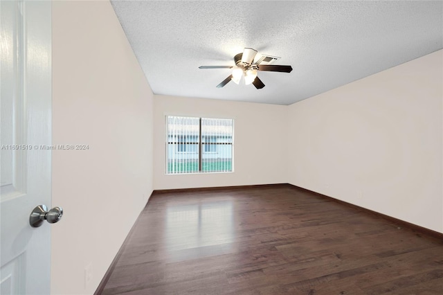 empty room featuring a textured ceiling, dark hardwood / wood-style floors, and ceiling fan