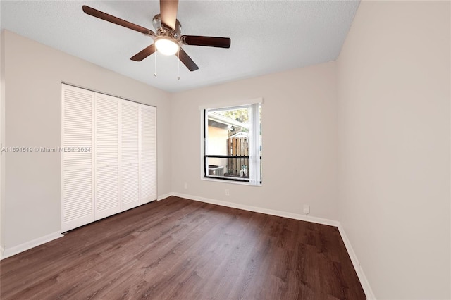 unfurnished bedroom with a closet, ceiling fan, dark hardwood / wood-style flooring, and a textured ceiling