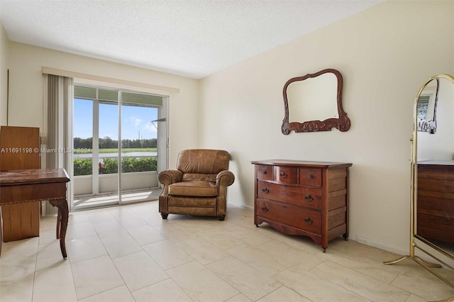 living area featuring a textured ceiling and light tile patterned floors