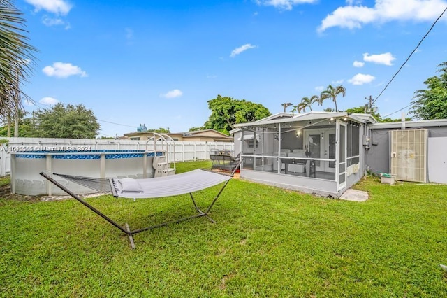 view of yard featuring a shed, a sunroom, and a fenced in pool