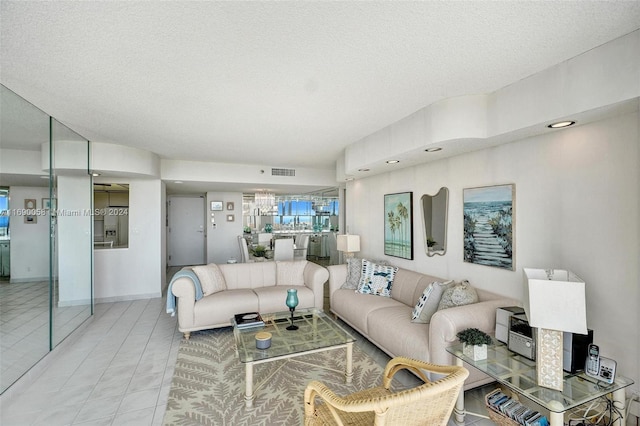 tiled living room featuring an inviting chandelier and a textured ceiling