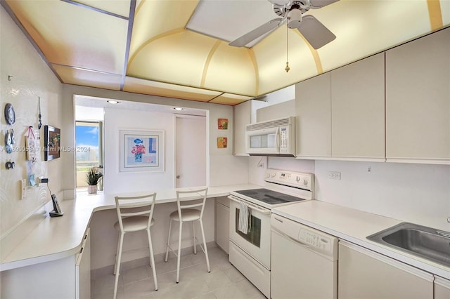 kitchen featuring sink, kitchen peninsula, ceiling fan, light tile patterned floors, and white appliances