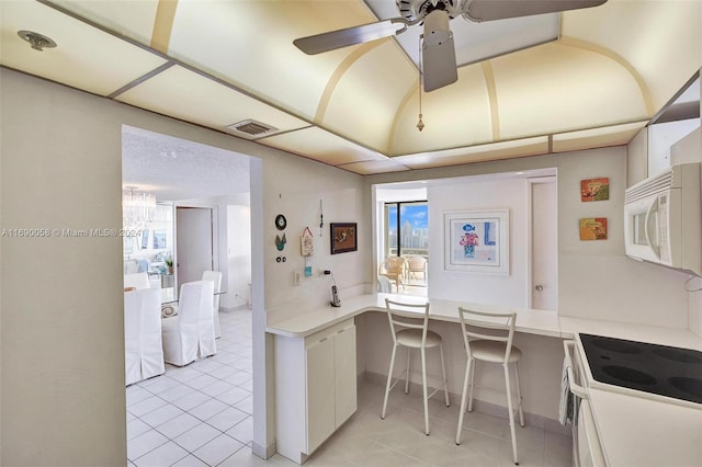 kitchen with a wealth of natural light, white appliances, built in desk, and ceiling fan with notable chandelier