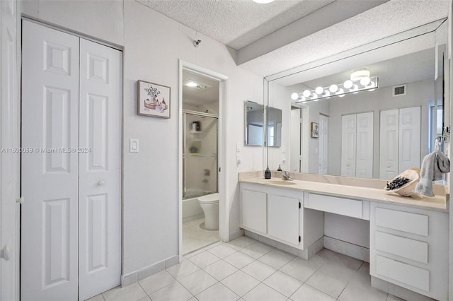 full bathroom with tile patterned flooring, a textured ceiling, combined bath / shower with glass door, vanity, and toilet