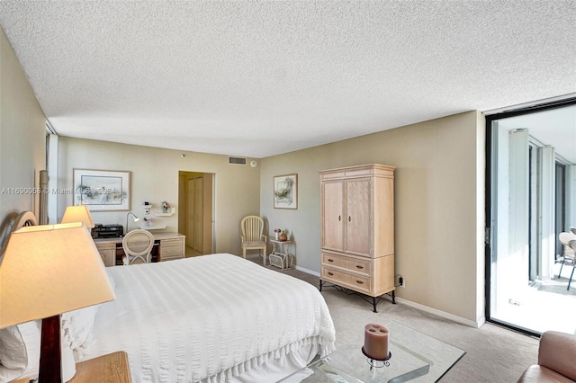 carpeted bedroom featuring a textured ceiling and access to exterior