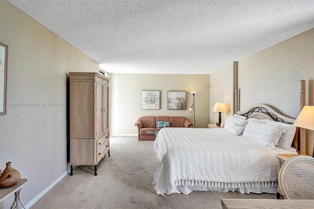 bedroom with a textured ceiling and light carpet