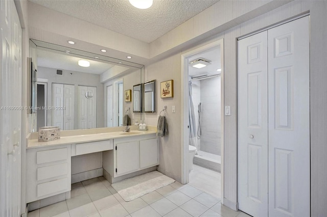 bathroom featuring tile patterned flooring, vanity, toilet, and a textured ceiling