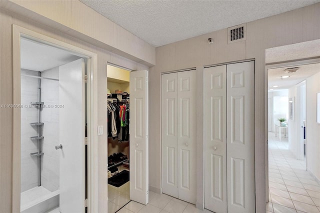 interior space featuring a textured ceiling and light tile patterned floors