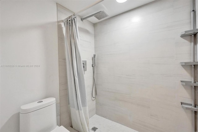 bathroom featuring a shower with shower curtain and toilet