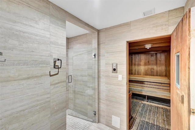 bathroom featuring tile walls and an enclosed shower