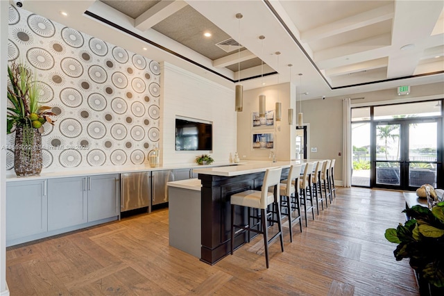 kitchen featuring a kitchen bar, french doors, coffered ceiling, gray cabinets, and hanging light fixtures