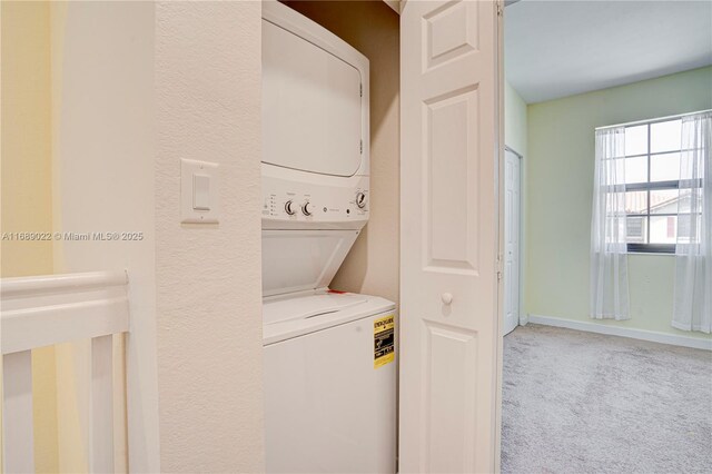 clothes washing area featuring carpet flooring and stacked washer and dryer