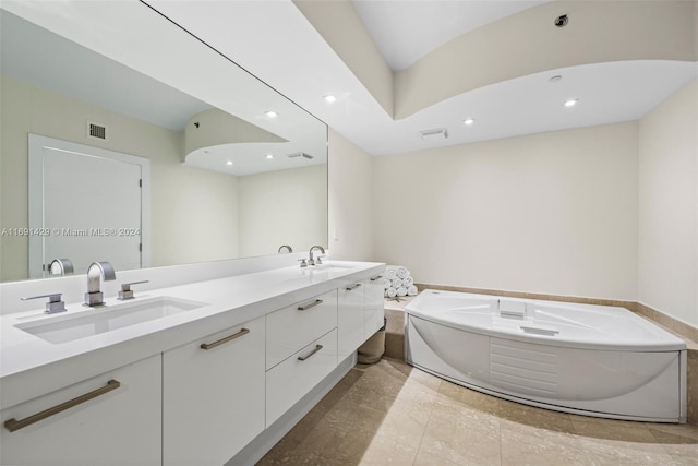 bathroom with a tub, tile patterned flooring, and vanity