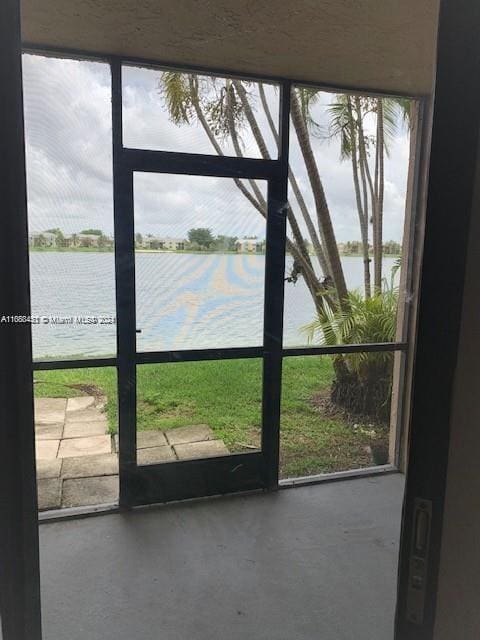 doorway featuring concrete flooring, a water view, and a healthy amount of sunlight