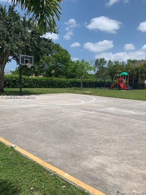 view of basketball court with a playground