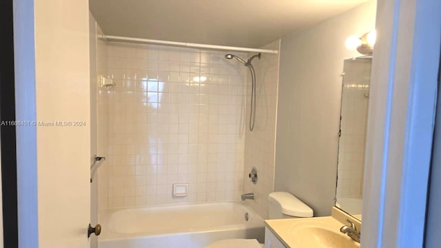 full bathroom with toilet, vanity, and tiled shower / bath