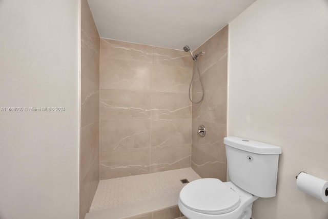 bathroom with toilet and a tile shower