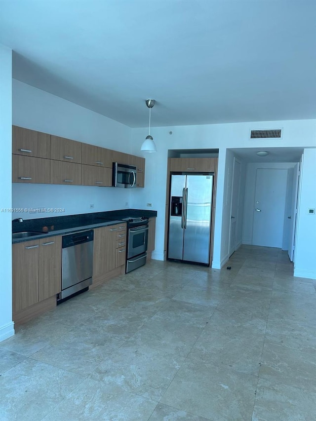 kitchen with sink, decorative light fixtures, and appliances with stainless steel finishes