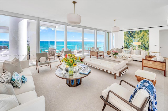 living room with a water view, a wall of windows, and carpet floors