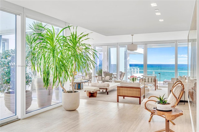 sunroom featuring a water view