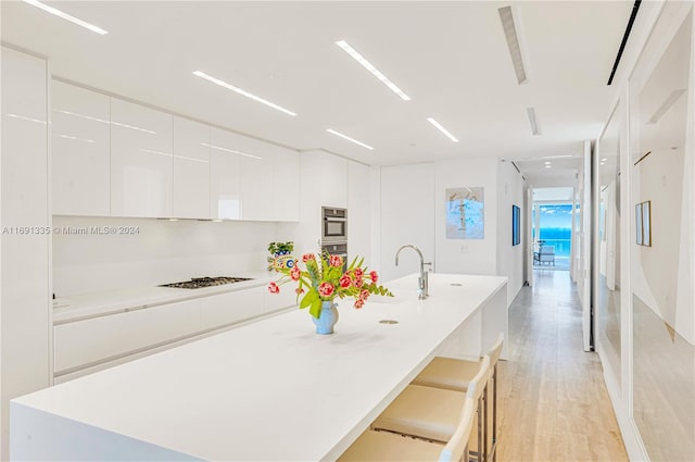 9111 Collins Ave Unit N-Ph6, Surfside, FL 33154 - kitchen with modern cabinets, white cabinetry, light wood finished floors, double oven, and gas stovetop