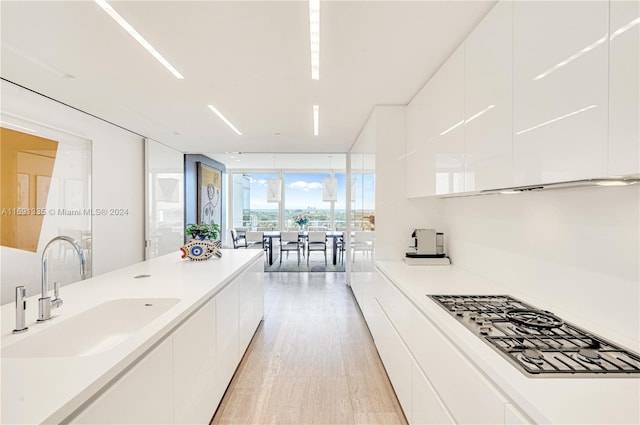 9111 Collins Ave Unit N-Ph6, Surfside, FL 33154 - kitchen with a sink, modern cabinets, a wall of windows, white cabinets, and stainless steel gas stovetop