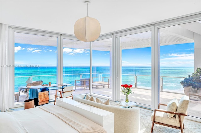 bedroom featuring multiple windows, a water view, and access to outside