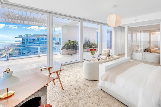 bedroom featuring a wall of windows, carpet floors, and access to outside