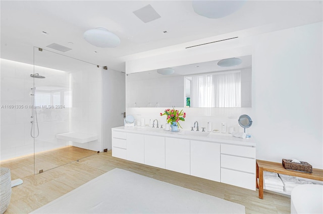 bathroom featuring tasteful backsplash, vanity, hardwood / wood-style flooring, and tiled shower