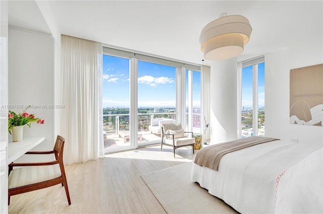 bedroom featuring hardwood / wood-style flooring, a wall of windows, and multiple windows