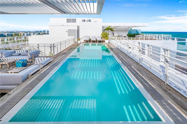 view of swimming pool featuring outdoor lounge area and a water view