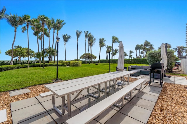 view of property's community with a lawn, a patio, and an outdoor living space