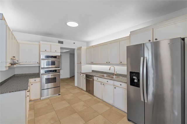 8855 Collins Ave Unit 5A, Surfside, FL 33154 - kitchen featuring appliances with stainless steel finishes, a sink, light tile patterned floors, dark stone countertops, and a warming drawer