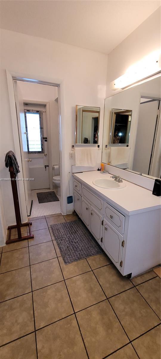 bathroom with tile patterned flooring, vanity, and toilet