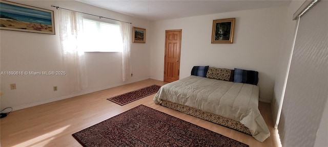 bedroom with a closet and light hardwood / wood-style flooring